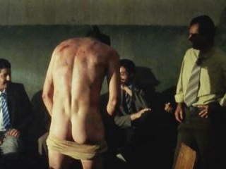 Sean is stripped by two guards, nicely showing off his butt when he lowers his shorts in front of a group of creepy guys while blindfolded!
