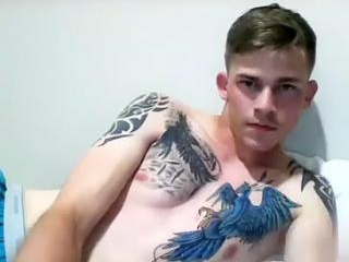 Handsome boy is playing in a small room and shooting himself on computer webcam