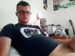 Handsome male is relaxing in a small room and memorializing himself on computer webcam